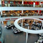 Photograph of journalists working at screens in a busy newsroom checking information.