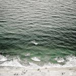 Ocean waves seen from above along a coastline