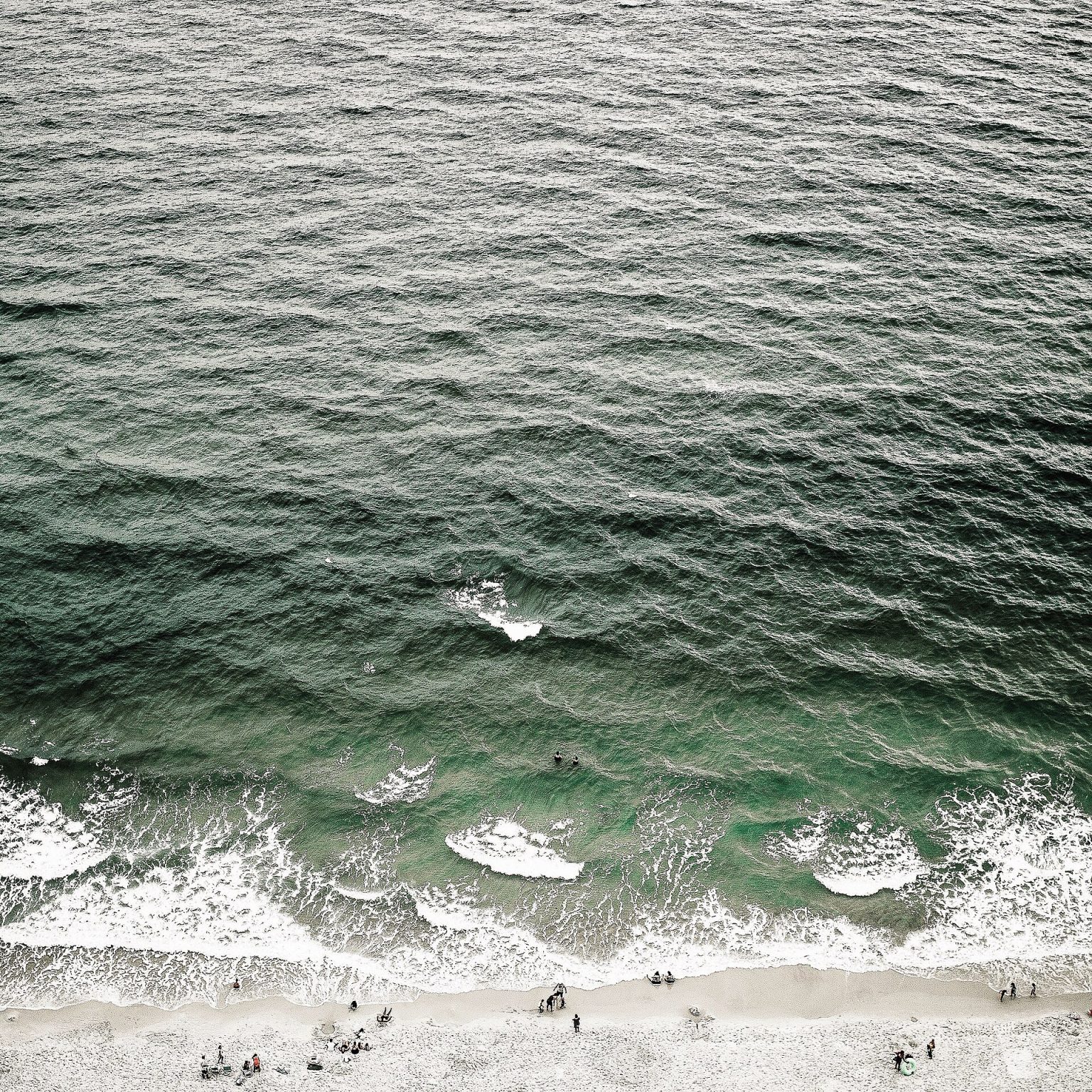 Ocean waves seen from above along a coastline